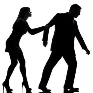one caucasian couple dispute separation man leaving and woman holding back in studio silhouette isolated on white background